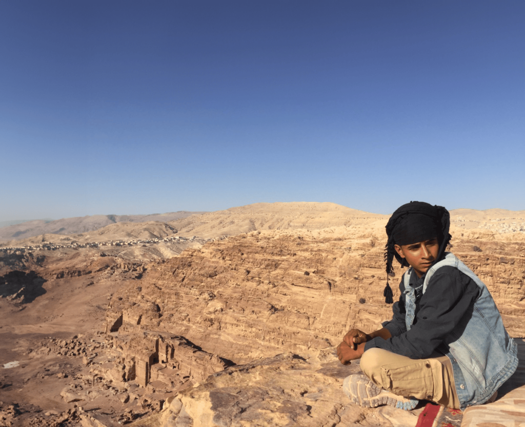 Chico sentado en un desierto